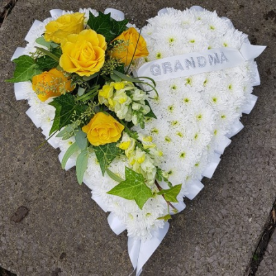 Heart SYM-324 - A white massed heart with yellow and purple spray, designed with love by our floristry team using the freshest flowers available.