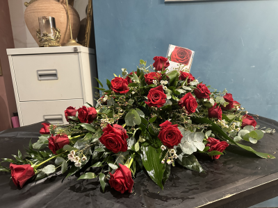 Single Ended Spray SYM-305 - This single ended spray is made using symbolic red roses for the perfect loving tribute. Same day delivery may not be possible on this design – please contact us to discuss your requirements.