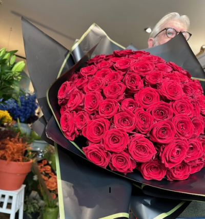 100 Red roses - 100 stems of beautiful red Naomi roses handtied and wrapped with black and gold cellophane. No foliage.